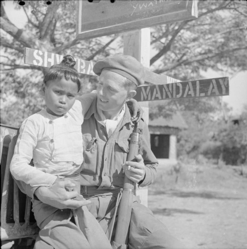 1945年3月，一名抱著緬甸兒童的英國士兵。圖片來源：Wikimedia Commons